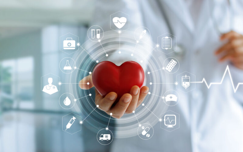 Medicine doctor holding red heart shape in hand and icon medical network connection with modern virtual screen interface, medical technology network concept