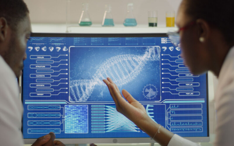 Scientist examines DNA models in modern Genetic Research Laboratory.