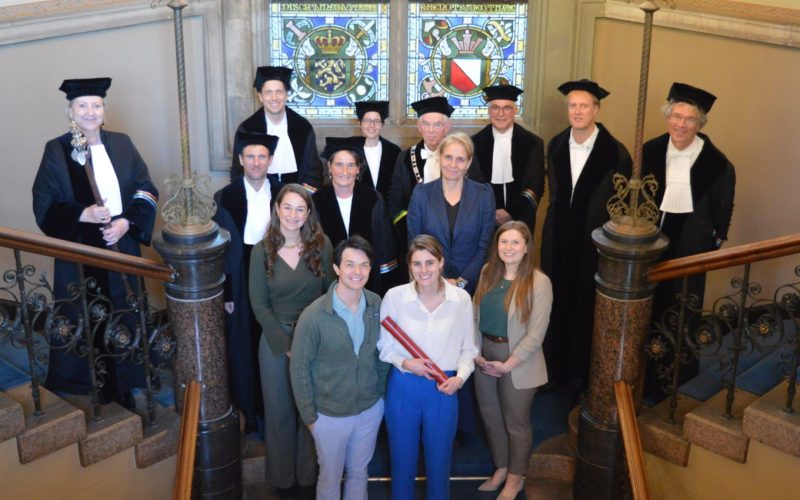 Lyanne Derksen with her promotors and loved ones on the stairs in the Academiegebouw Utrecht.