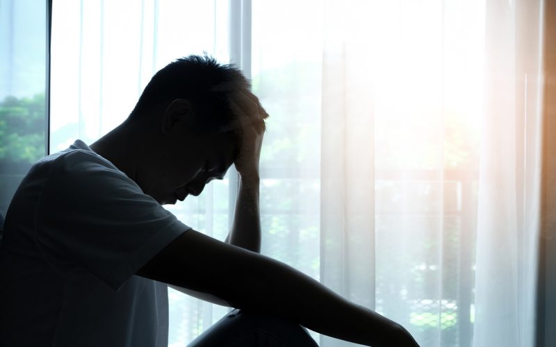 The man sitting in the corner of the room has emotional and mental problems