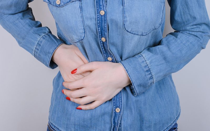 Holding hand on side of body because of pain