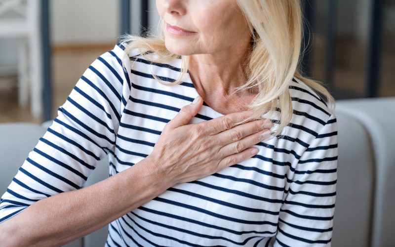 Woman holds hand on chest