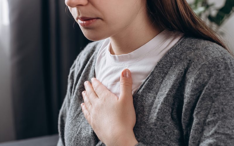 Woman with hand on heart because of heart issues