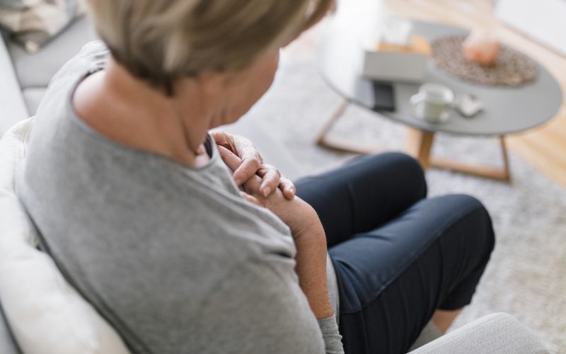 Elderly woman at home with heart pain holding her chest