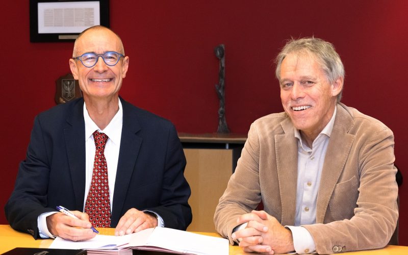 A U-TRIAL representatieve and Arno Hoes sign the contract.